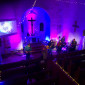 Die in blau und violett angestrahlte Christuskirche von der Empore aus fotografiert, vorne spielt die Band.